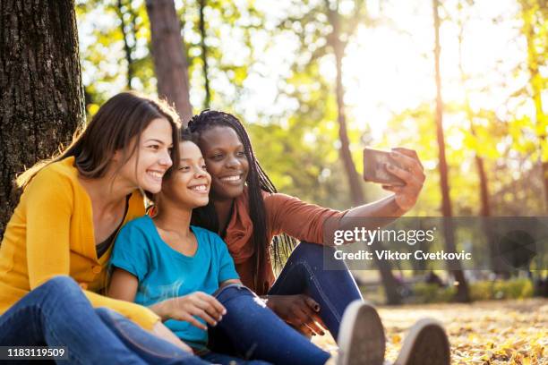 multi ethnic friends with child taking selfie - teen lesbians stock pictures, royalty-free photos & images