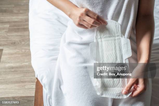 woman holding sanitary napkins or menstruation pad before wearing it. women using it during menstruation to avoid damage to clothing. - damenbinde stock-fotos und bilder