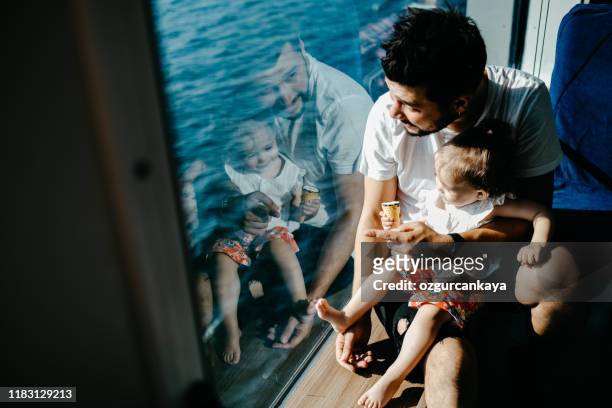 girl traveling by ship with her father and looking through the window - ferry passenger stock pictures, royalty-free photos & images