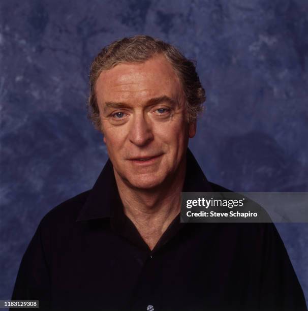 Portrait of English actor Michael Caine as he poses in front of a blue background, Los Angeles, California, 1991.