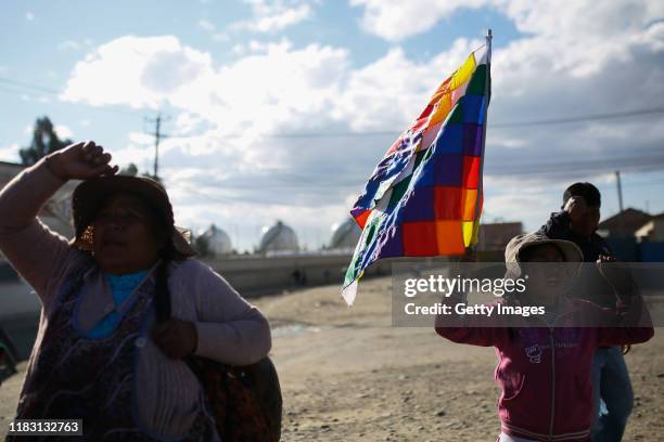 An little girl holds a Wiphala flag, representing some of the native people of the Andes, during a blockade of a road to a Yacimientos Petroliferos...