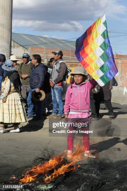 An little girl holds a Wiphala flag, representing some of the native people of the Andes, during a blockade of a road to a Yacimientos Petroliferos...