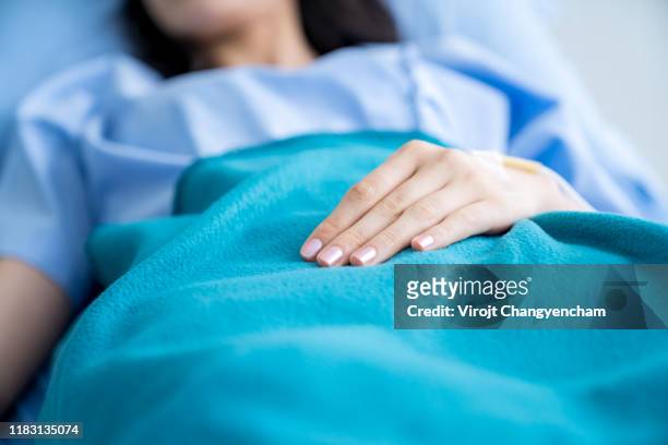 close-up hands of patient recovering on the hospital bed - medvetslös bildbanksfoton och bilder