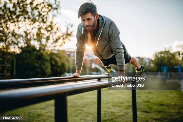 young man exercising in open air gym - open workouts stock pictures, royalty-free photos & images