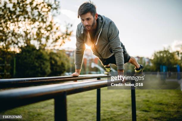 young man exercising in open air gym - open workouts imagens e fotografias de stock