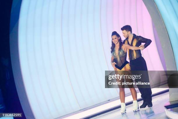 November 2019, North Rhine-Westphalia, Cologne: Sarah Lombardi, singer and last year's winner, and Joti Polizoakis, ice dancer, are on the ice in the...