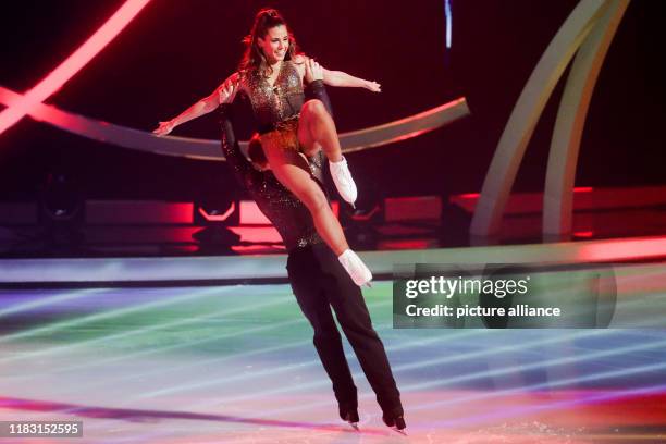 November 2019, North Rhine-Westphalia, Cologne: Sarah Lombardi, singer and last year's winner, and Joti Polizoakis, ice dancer, are on the ice in the...