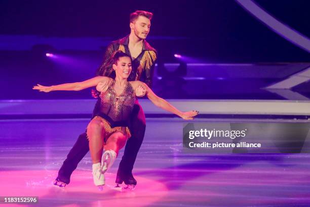 November 2019, North Rhine-Westphalia, Cologne: Sarah Lombardi, singer and last year's winner, and Joti Polizoakis, ice dancer, are on the ice in the...