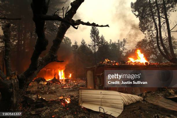 Homes continue to burn after the Kincade Fire moved through the area on October 24, 2019 in Geyserville, California. Fueled by high winds, the...