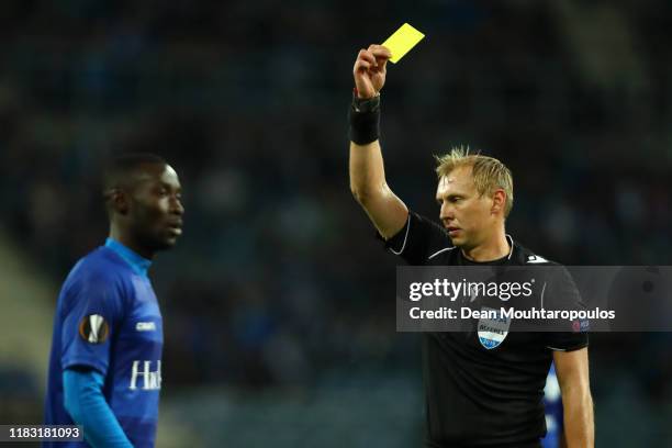 Nana Asare of Gent is shown a yellow card by referee Sergei Ivanov during the UEFA Europa League group I match between KAA Gent and VfL Wolfsburg at...