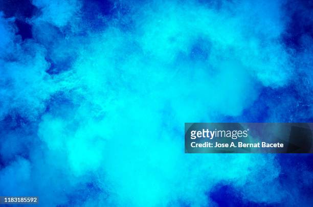 explosion by an impact of a cloud of particles of powder and smoke of blue background. - blue smoke stockfoto's en -beelden