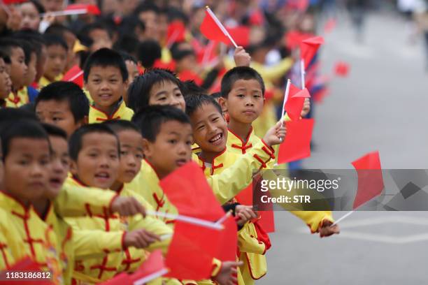 This photo taken on November 17, 2019 shows students cheering during the Guizhou Tour of Leigong Mountain 100km International Marathon in Danzhai in...