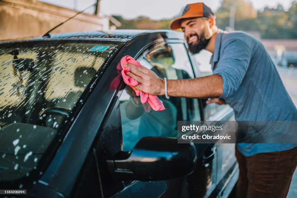 Handsome man washing car