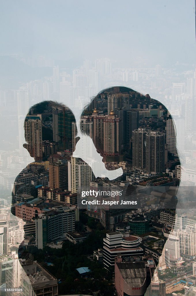 Double exposure of woman holding baby and cityscap