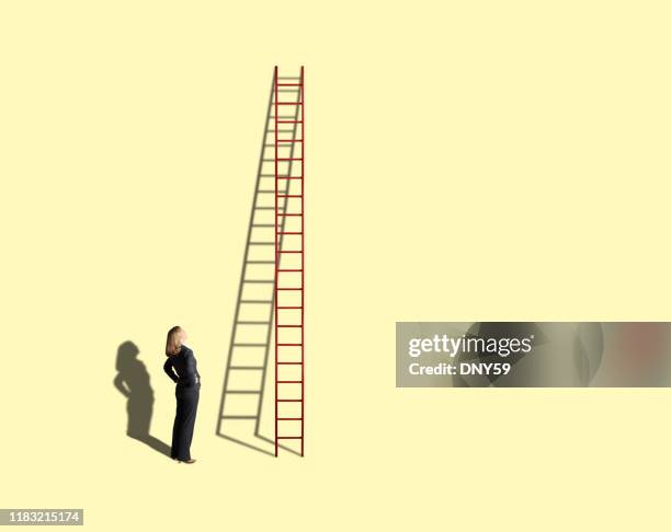 businesswoman looking up at tall ladder on yellow background - ladder stock pictures, royalty-free photos & images