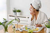 Young woman applying face mask at home. Natural Skin Care Routine For Glowing Skin.