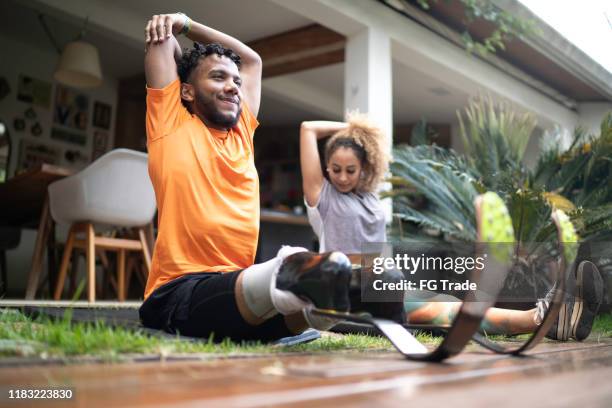 friends stretching in the yard - amputee woman imagens e fotografias de stock