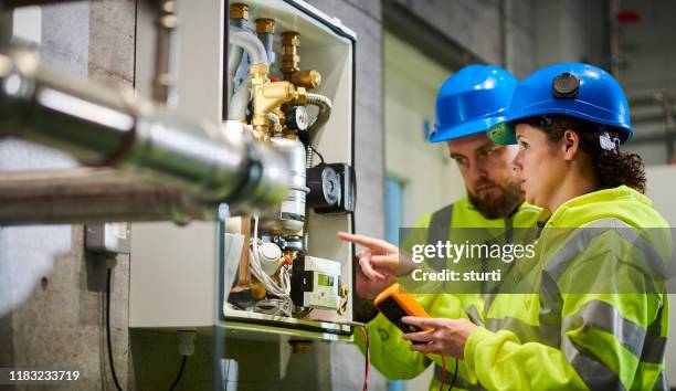 ingenieros eléctricos en la sala de calderas - suministro de energía fotografías e imágenes de stock