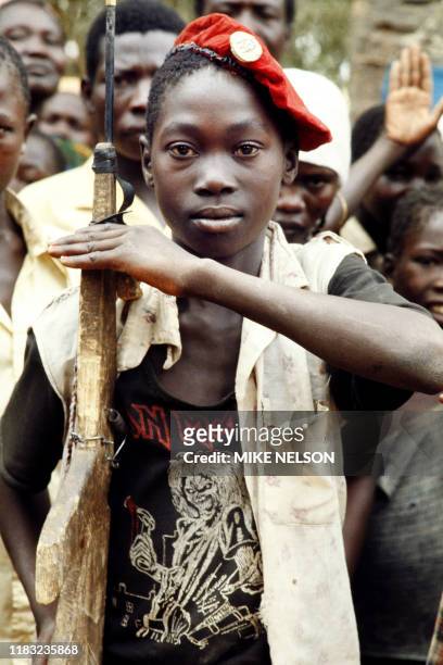 Young Chadian boy scout salutes, holding a wooden rifle, on February 23 in Doba during the Chadian-Libyan conflict.