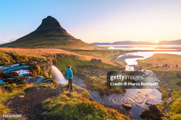 man admiring the sunrise at mount kirkjufell, iceland - island holiday stock-fotos und bilder