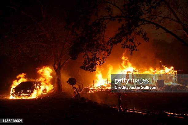 Homes continue to burn after the Kincade Fire moved through the area on October 24, 2019 in Geyserville, California. Fueled by high winds, the...