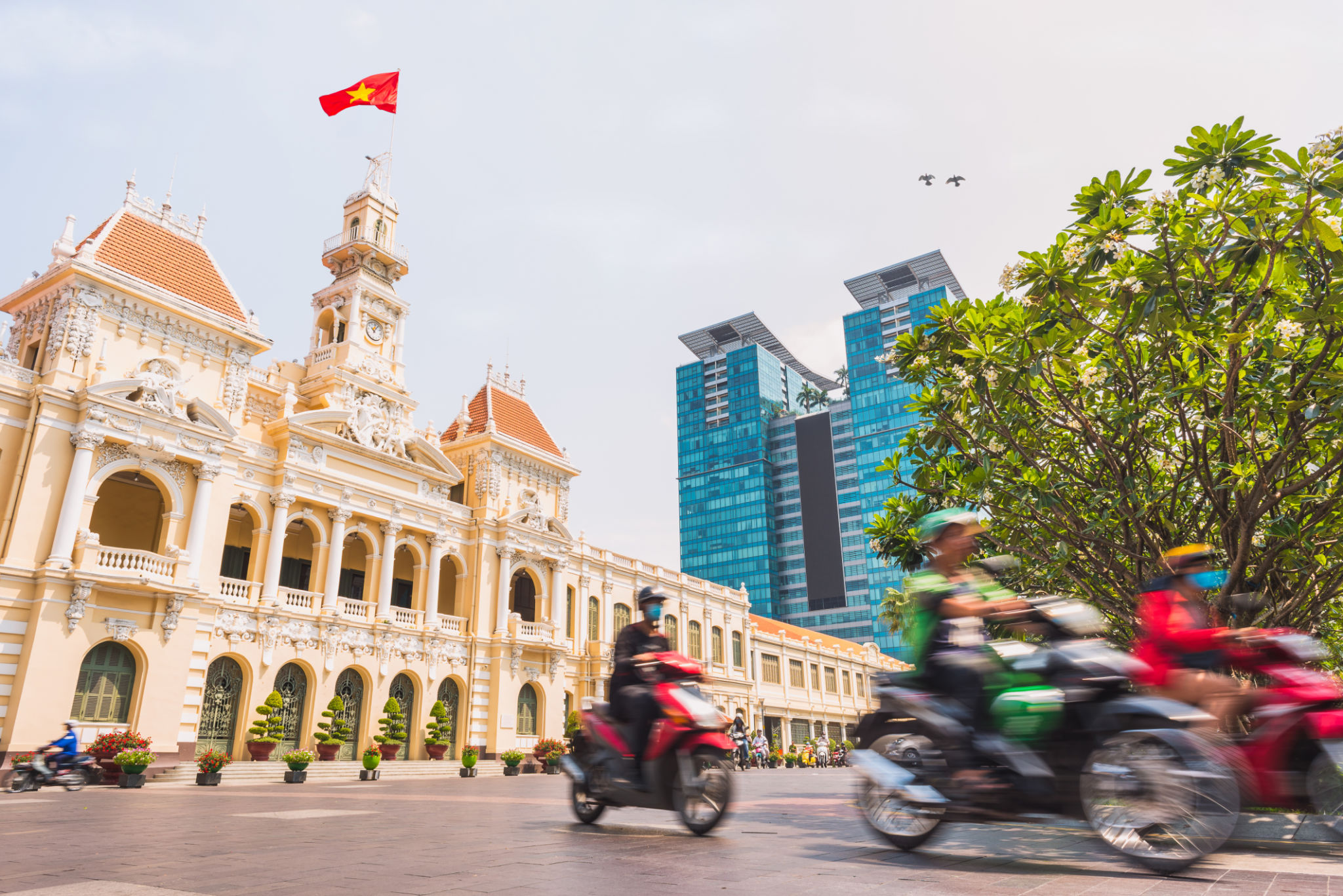 Ho Chi Minh City, Vietnam: Saigon City Hall, Vincom Center towers and colorful street traffic Ho Chi Minh City, Vietnam: Saigon City Hall, Vincom Center towers and colorful street traffic