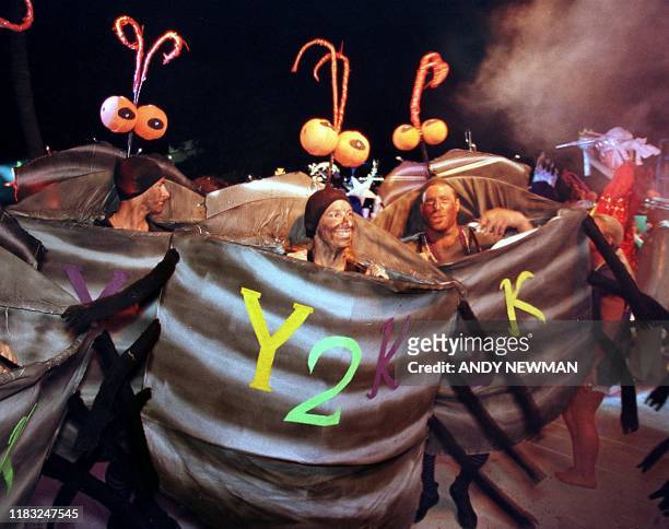 Contestants costumed as "Y2K Bugs" dance and prance during the Pier House Pretenders in Paradise Costume Competition early 29 October 1999 as part of...