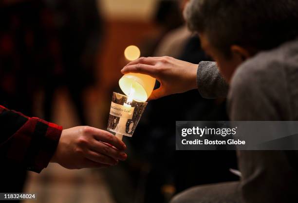 Attendees light candles during a vigil for the Transgender Day of Remembrance at The Cathedral Church of St. Paul in downtown Boston on Nov. 17,...