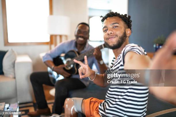 selfie de padre e hijo tocando música en la sala de estar - uncle fotografías e imágenes de stock