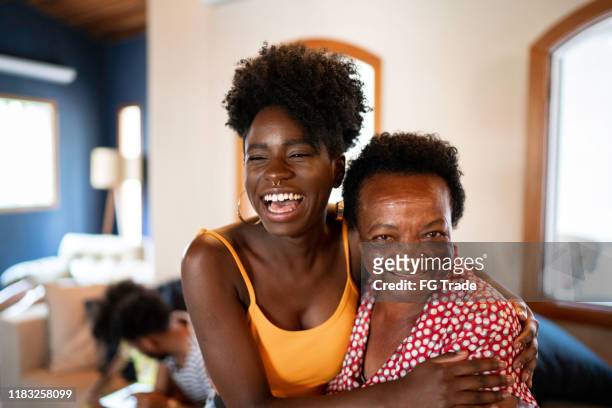 happy mother and daughter embracing - black family reunion stock pictures, royalty-free photos & images