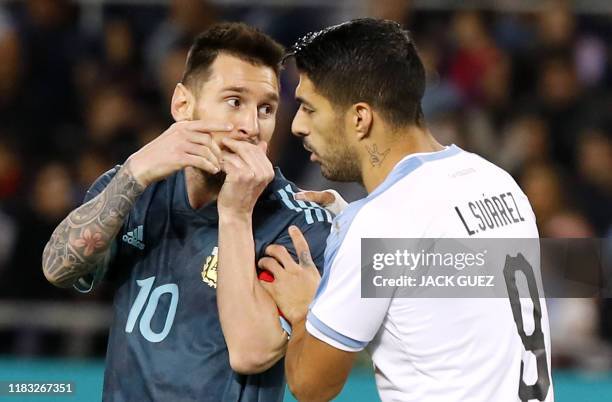 Argentina's forward Lionel Messi talks with Uruguay's forward Luis Suarez during the friendly football match between Argentina and Uruguay at the...
