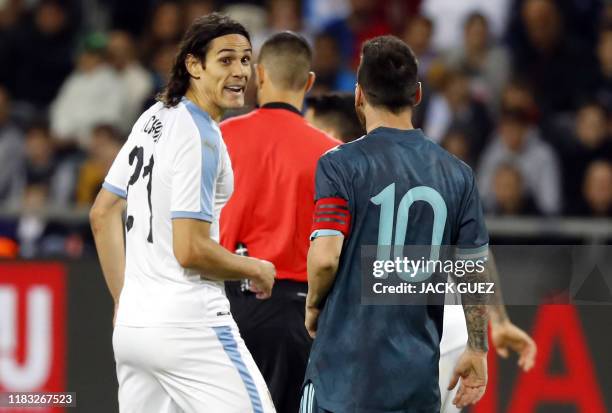 Argentina's forward Lionel Messi and Uruguay's forward Edinson Cavani are pictured on the pitch the friendly football match between Argentina and...