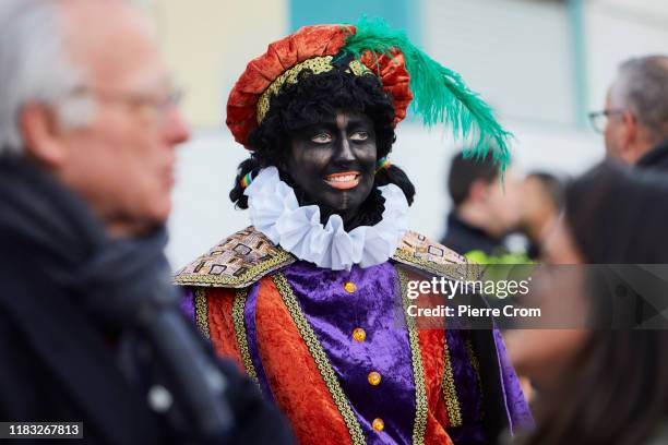 Dutch woman is seen dressed as a Saint-Nicholas helper called Black Pete during the traditional Saint-Nicholas parade on November 16, 2019 in The...