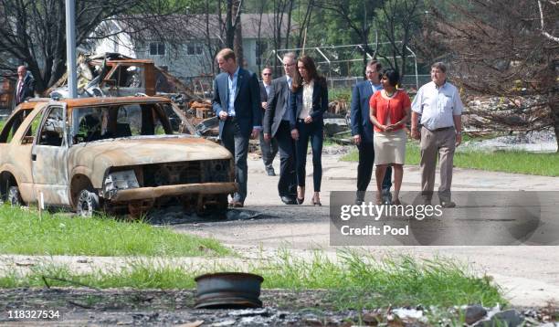 Prince William, Duke of Cambridge and Catherine, Duchess of Cambridge inspect a fire-damaged car in a part of town devastated by a fire in May 2011,...