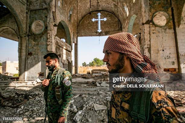 Members of the Khabour Guards Assyrian Syrian militia, affiliated with the Syrian Democratic Forces , walk in the ruins of the Assyrian Church of the...