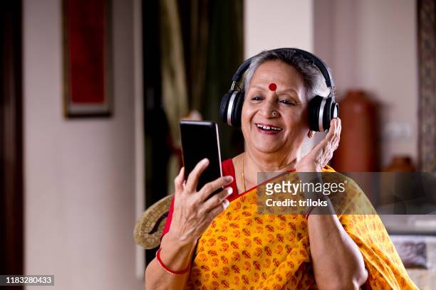 在家聽音樂的資深婦女 - indian music 個照片及圖片檔