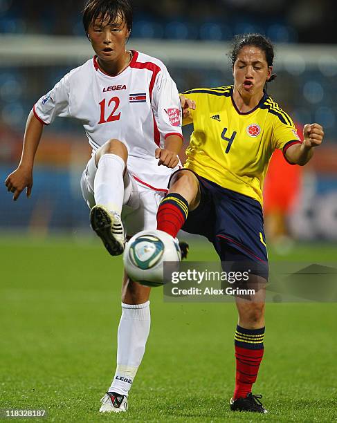 Jon Myong Hwa of Korea DPR is challenged by Diana Ospina of Colombia during the FIFA Women's World Cup 2011 Group C match between Korea DPR and...