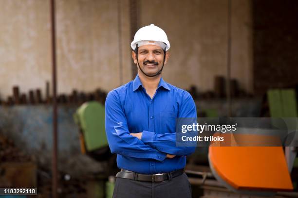 positiver männlicher architekt auf der baustelle - indian engineer stock-fotos und bilder