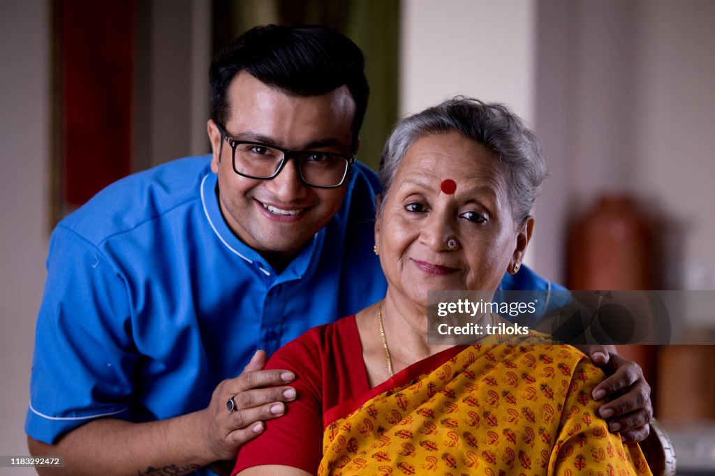 Male nurse caring old woman at home