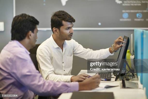 mannelijke indiase collega's zitten samen op desktop pc - india partition stockfoto's en -beelden