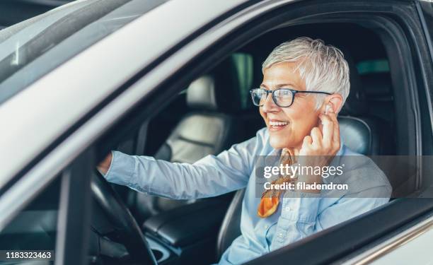 donna a mani libere in auto - hands free device foto e immagini stock