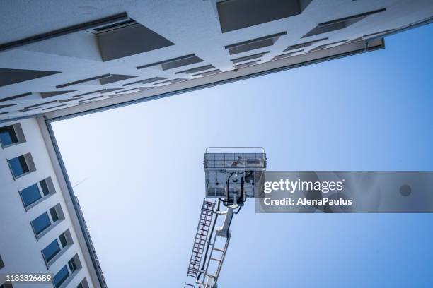 il camion del cestino dei soccorsi dei vigili del fuoco si solleva in alto in aria - lift foto e immagini stock