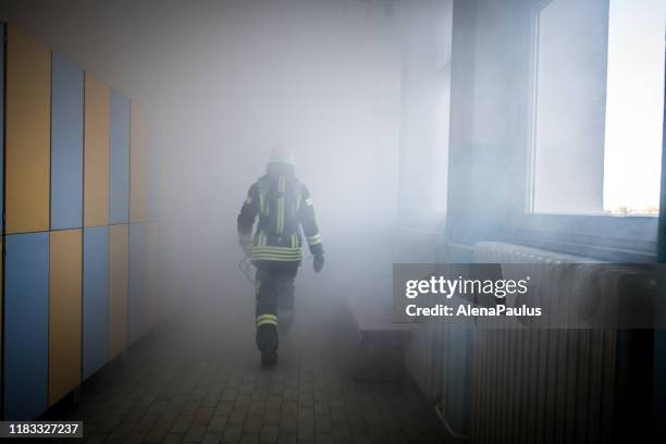 bombero en operación de rescate de incendios - firefighter fotografías e imágenes de stock