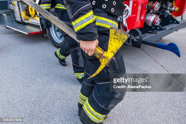 firefighter holding an axe in his hand, close up - fireman axe stock pictures, royalty-free photos & images