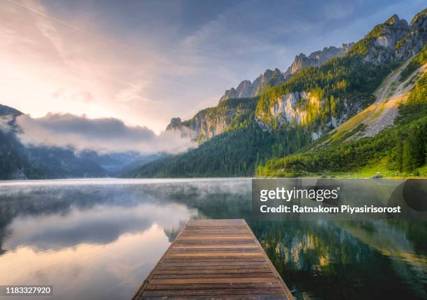 fantastic sunrise scene with fog over lake at azure alpine lake vorderer gosausee. gosau valley in upper austria - landschap natuur stockfoto's en -beelden
