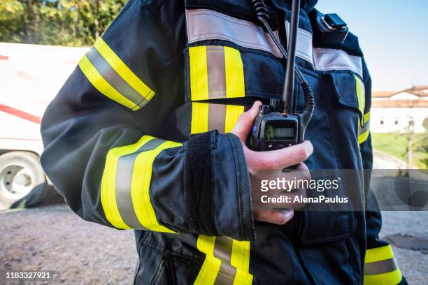 firefighter using walkie talkie, rescue operation close up - radio stock pictures, royalty-free photos & images