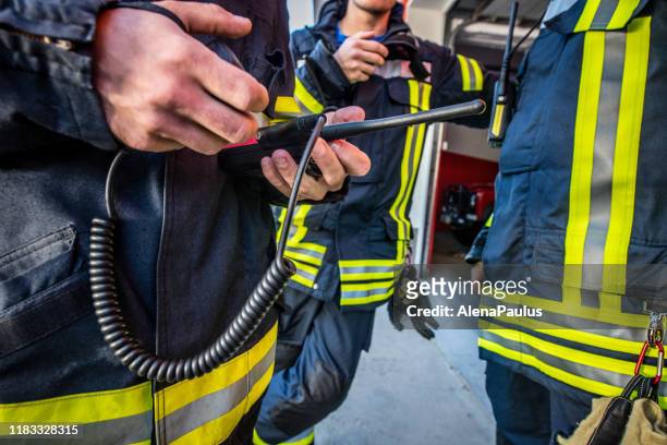 firefighters using walkie talkie, rescue operation close up - emergancy communication stock pictures, royalty-free photos & images