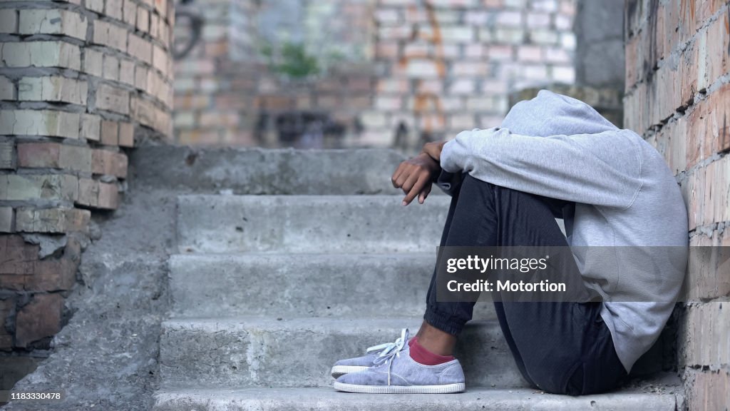 Einsame männliche teen sitzen Gebäude Treppe, Missverständnis Depression, Problem