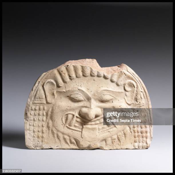Terracotta gorgoneion antefix , Archaic, circa 580-570 BC, Greek, Terracotta, H. 6 3/4 inches , Terracottas, The frightening features of this Gorgon...