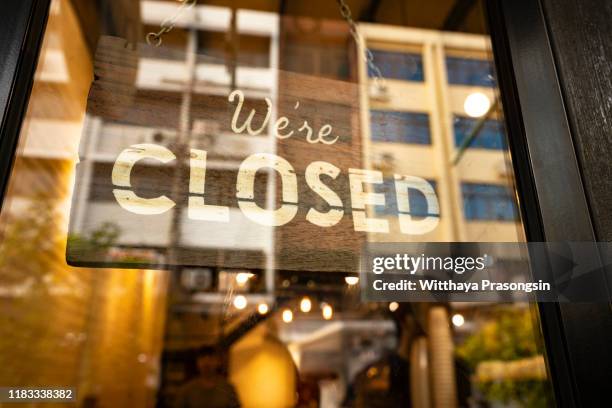 closed sign hanging in business window by a string - crooked with glob of glue also attaching it to window - bankruptcy stock-fotos und bilder